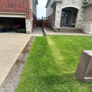 Exposed aggregate concrete driveway with decorative stone texture.