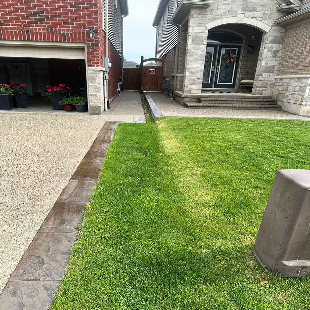 Exposed aggregate concrete driveway with decorative stone texture.