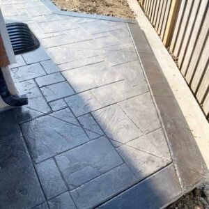 Grey stamped concrete walkway with dark slate border.
