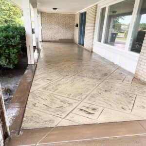 Earth-tone stamped concrete with brick-pattern border.