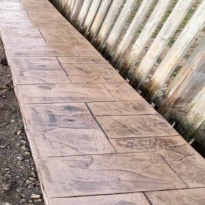 Cobblestone pattern stamped concrete side path.