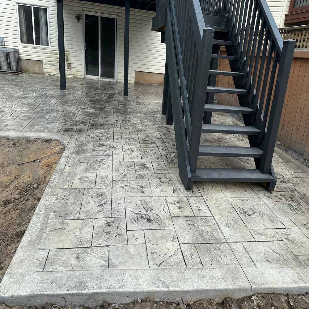 Large-tile stamped concrete backyard patio.